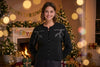Woman wearing a black cardigan with floral embroidery on a white background