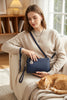Navy blue handbag with a strap on a white background